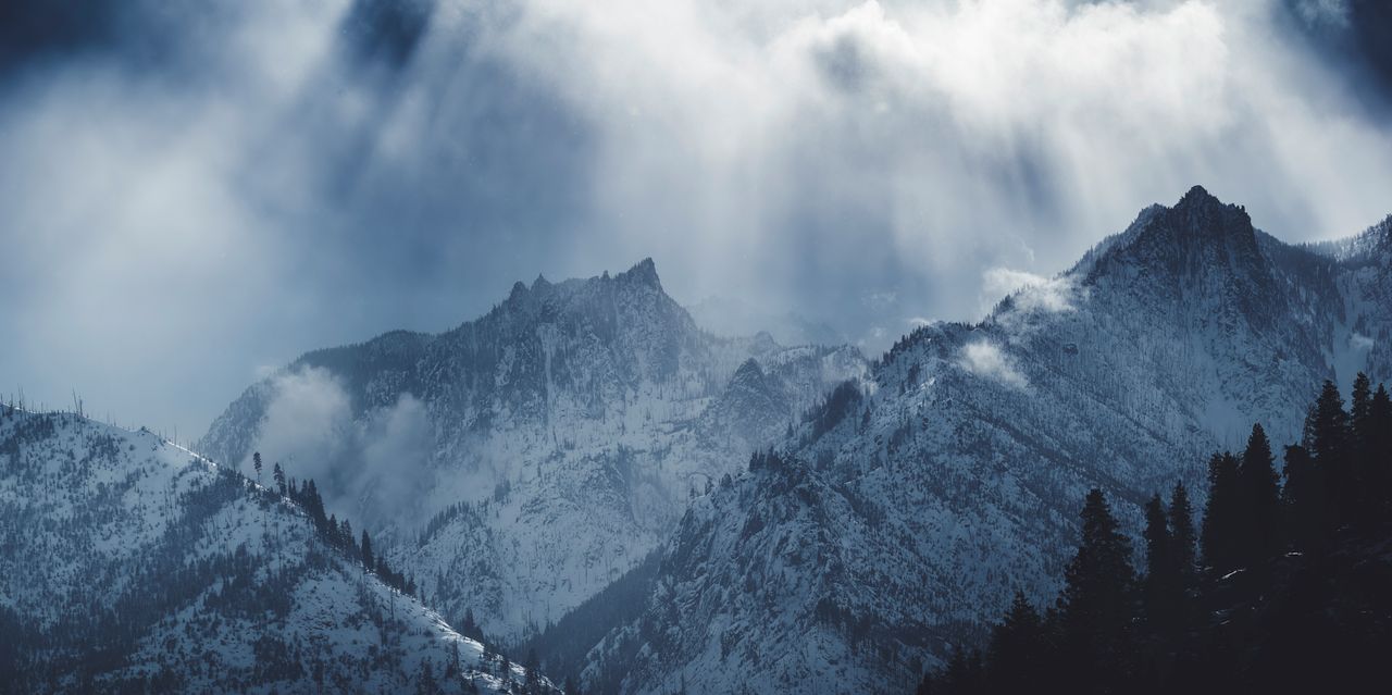 Mastering the First Impression: Your intriguing post title goes here Breathtaking winter view of snow-covered mountains in Leavenworth, WA with dramatic clouds and sunbeams.