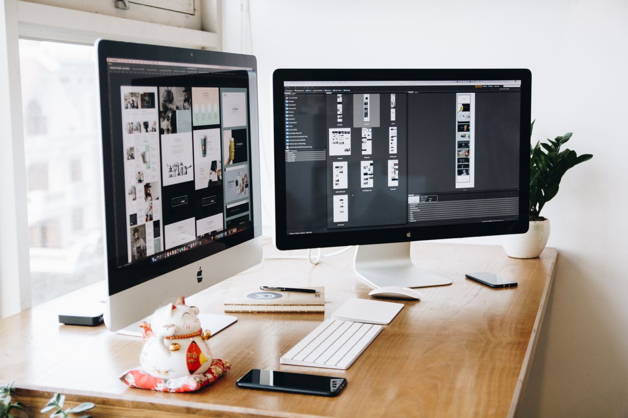 who-we-are A well-organized design workspace with dual monitors and design software on display.