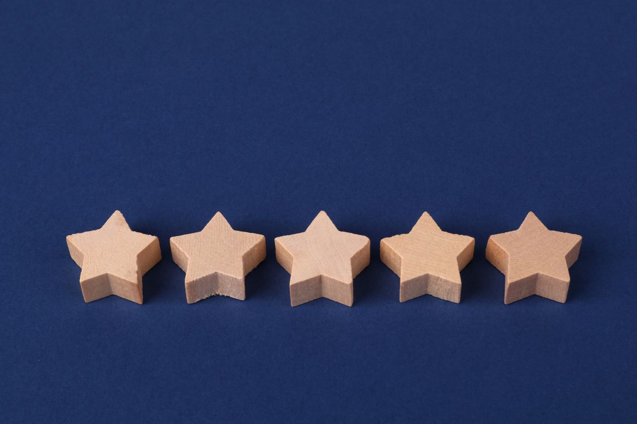 services-04 Five wooden stars on a blue background representing a rating system or evaluation concept.
