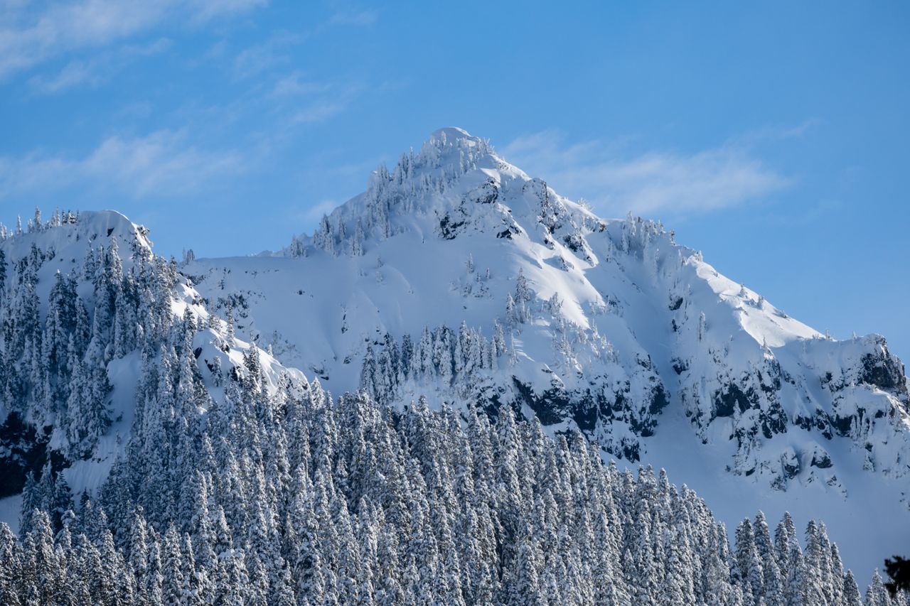 Stunning view of a snow-capped mountain peak under a vibrant blue sky, captured during winter.